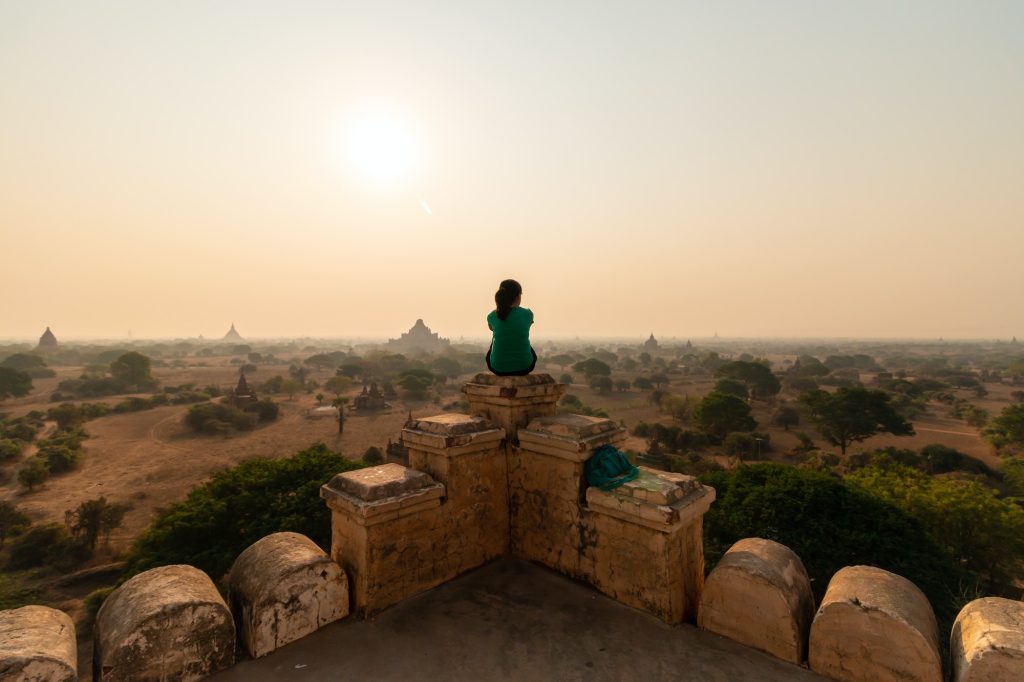 Lone person sits on top of a temple overlooking old bagan myanmar.jpg