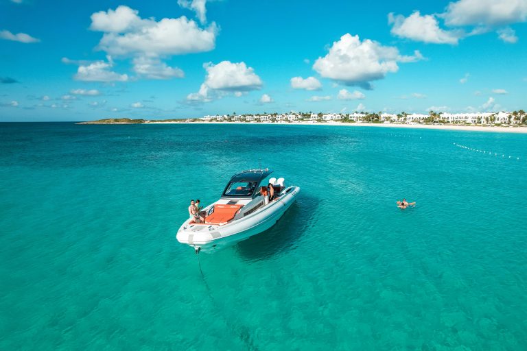 Crystal clear water with a speed boat in the middle .