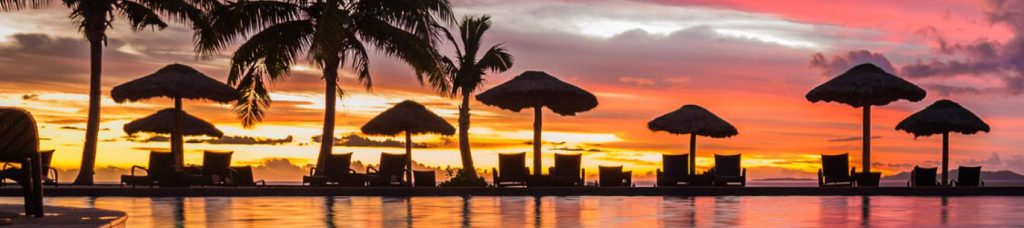 The sun setting in the background of the beach in Fiji.