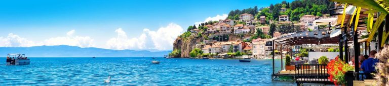 A picture of a mountain side that peaks into the blue ocean of Macedonia.